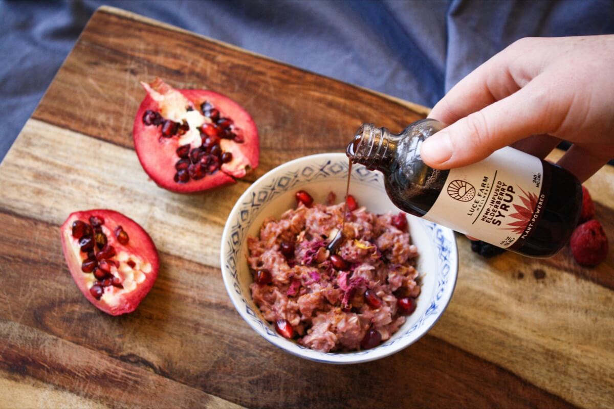 Pouring hemp infused elderberry syrup into oatmeal