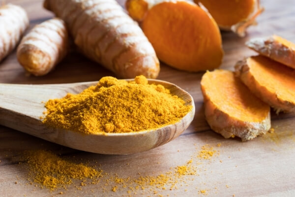 Turmeric powder on wooden spoon