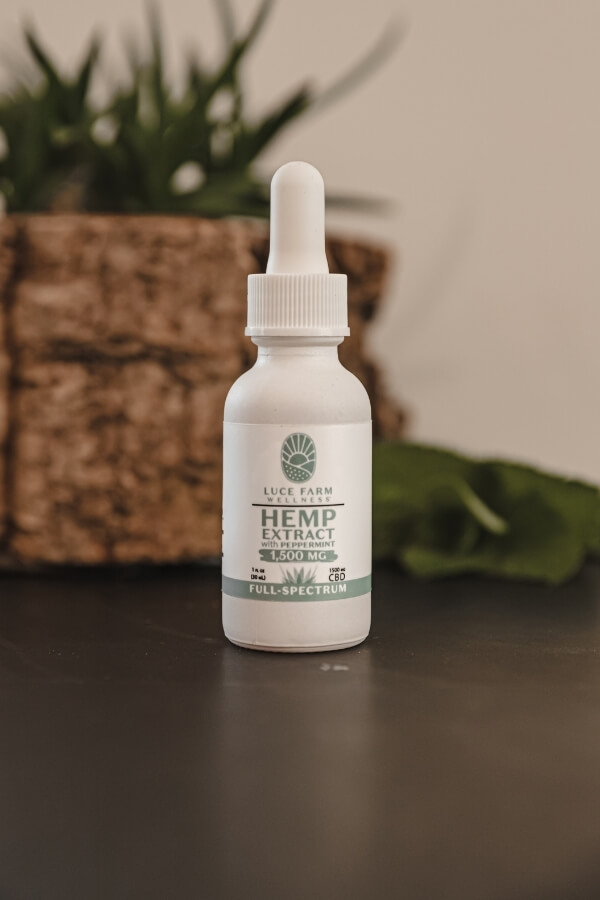 Luce Farm hemp extract bottle with plant behind